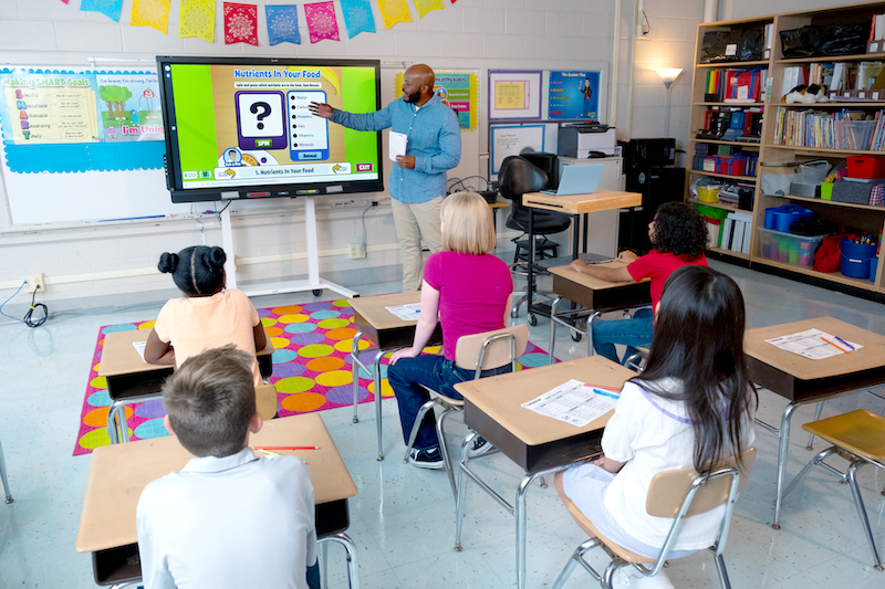 Teacher going through a nutrition lesson in front of an elementary class