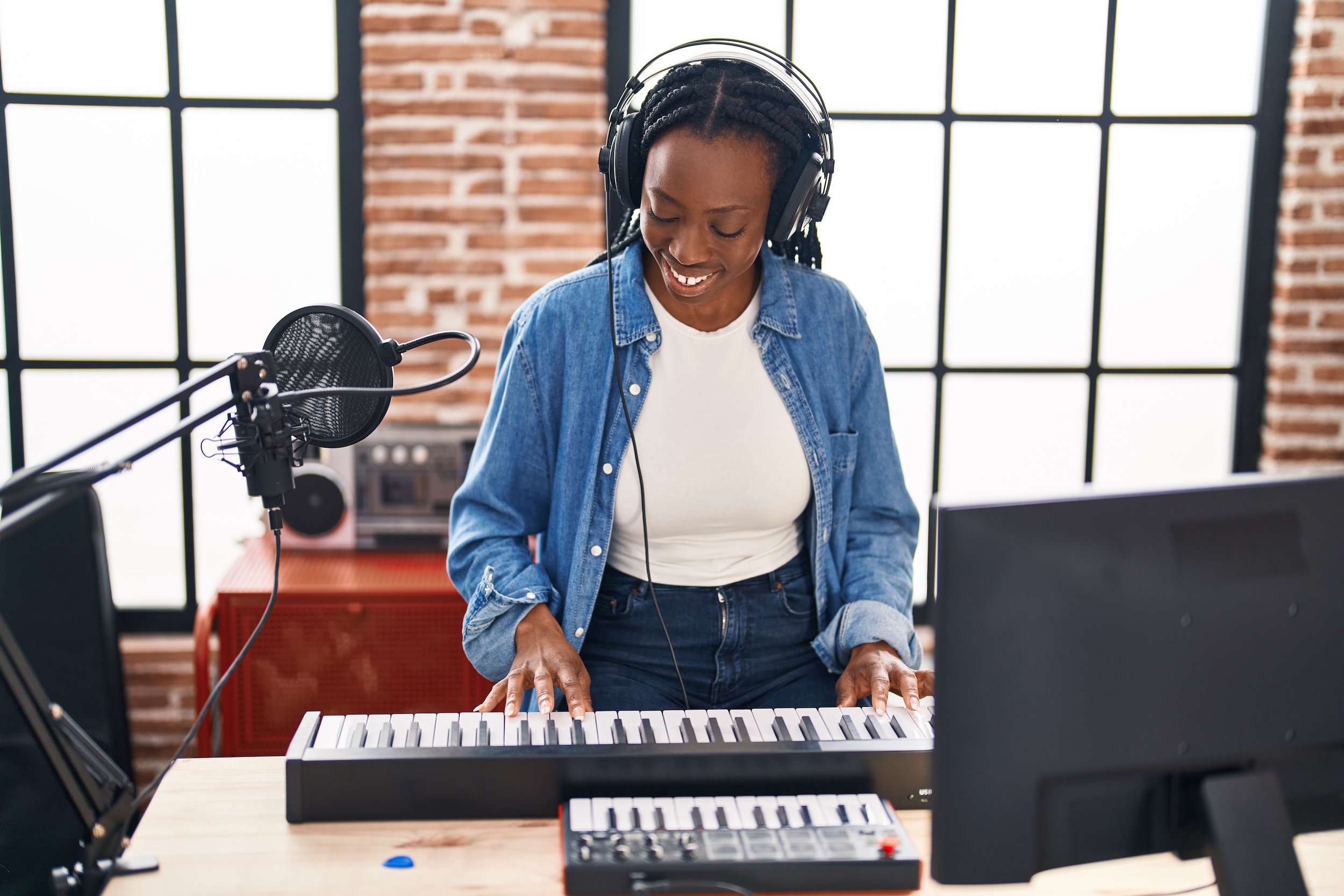 Student playing keyboard while wearing headphones